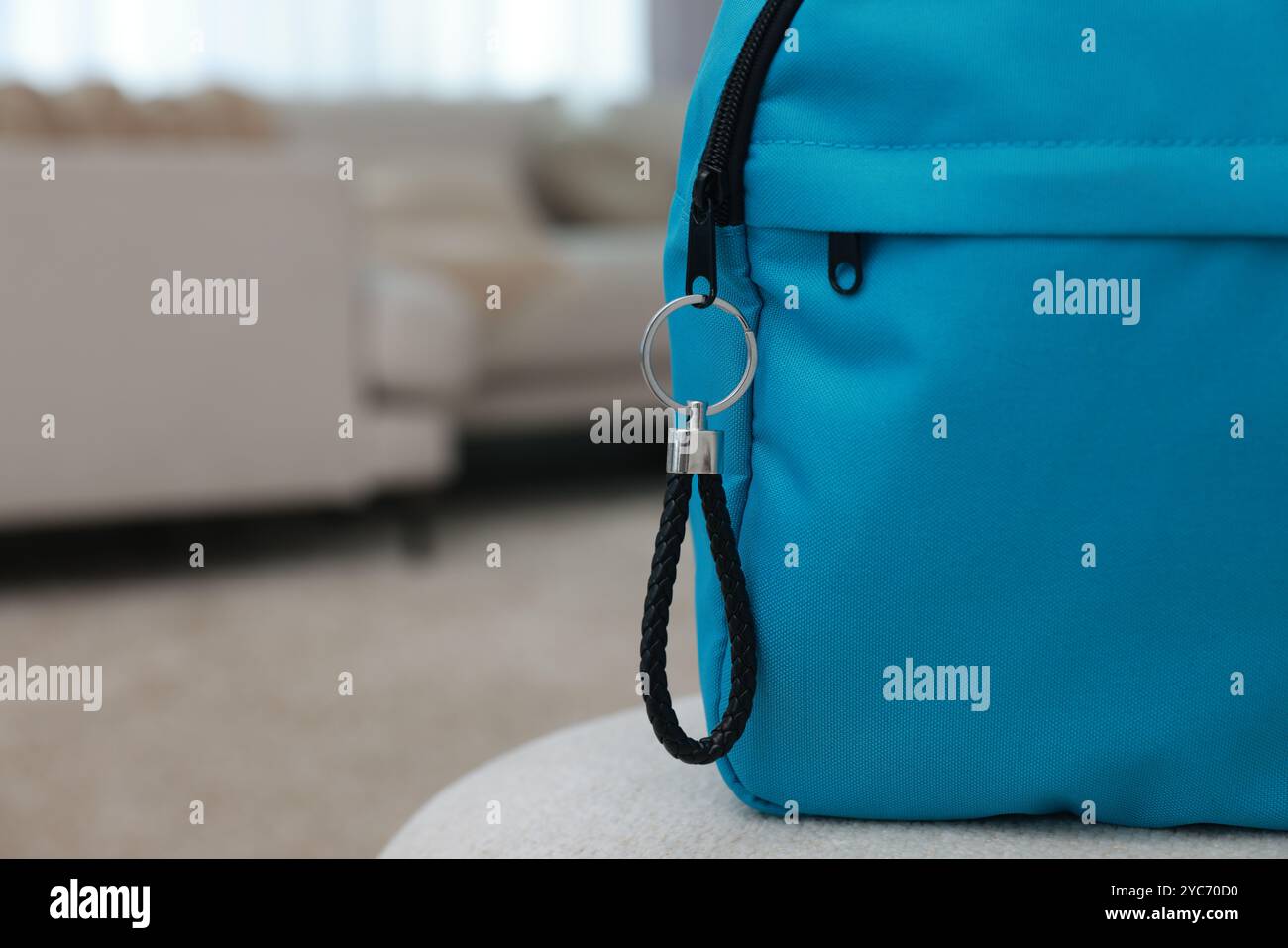 Backpack with black leather keychain on soft surface indoors, closeup. Space for text Stock Photo