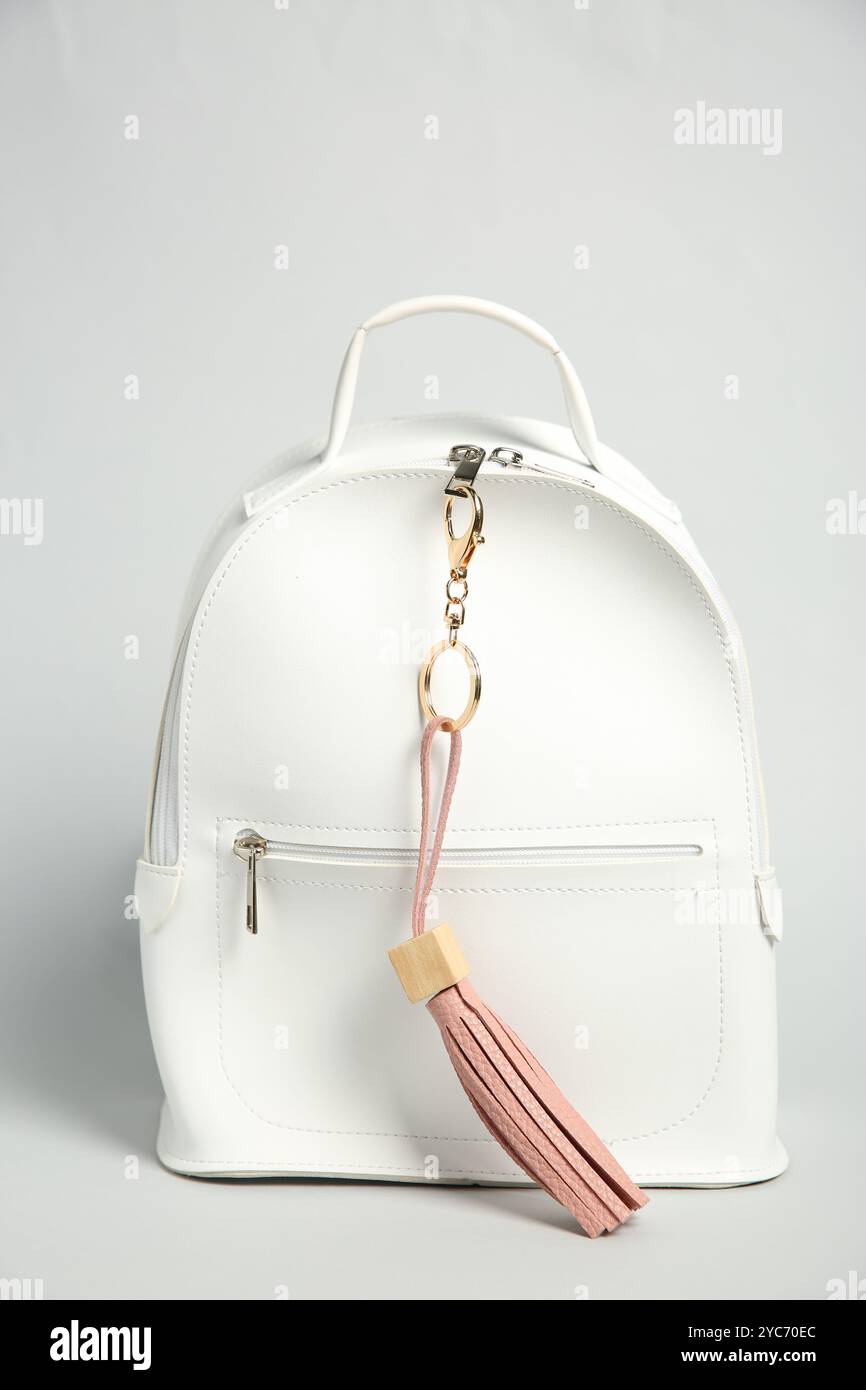 Backpack with pink leather keychain on grey background Stock Photo