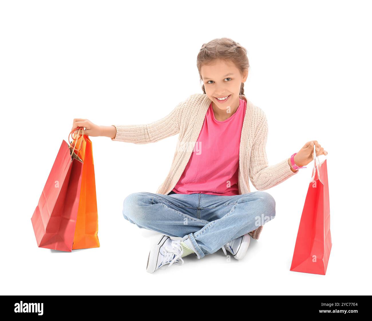 Little girl with shopping bags sitting on white background Stock Photo ...