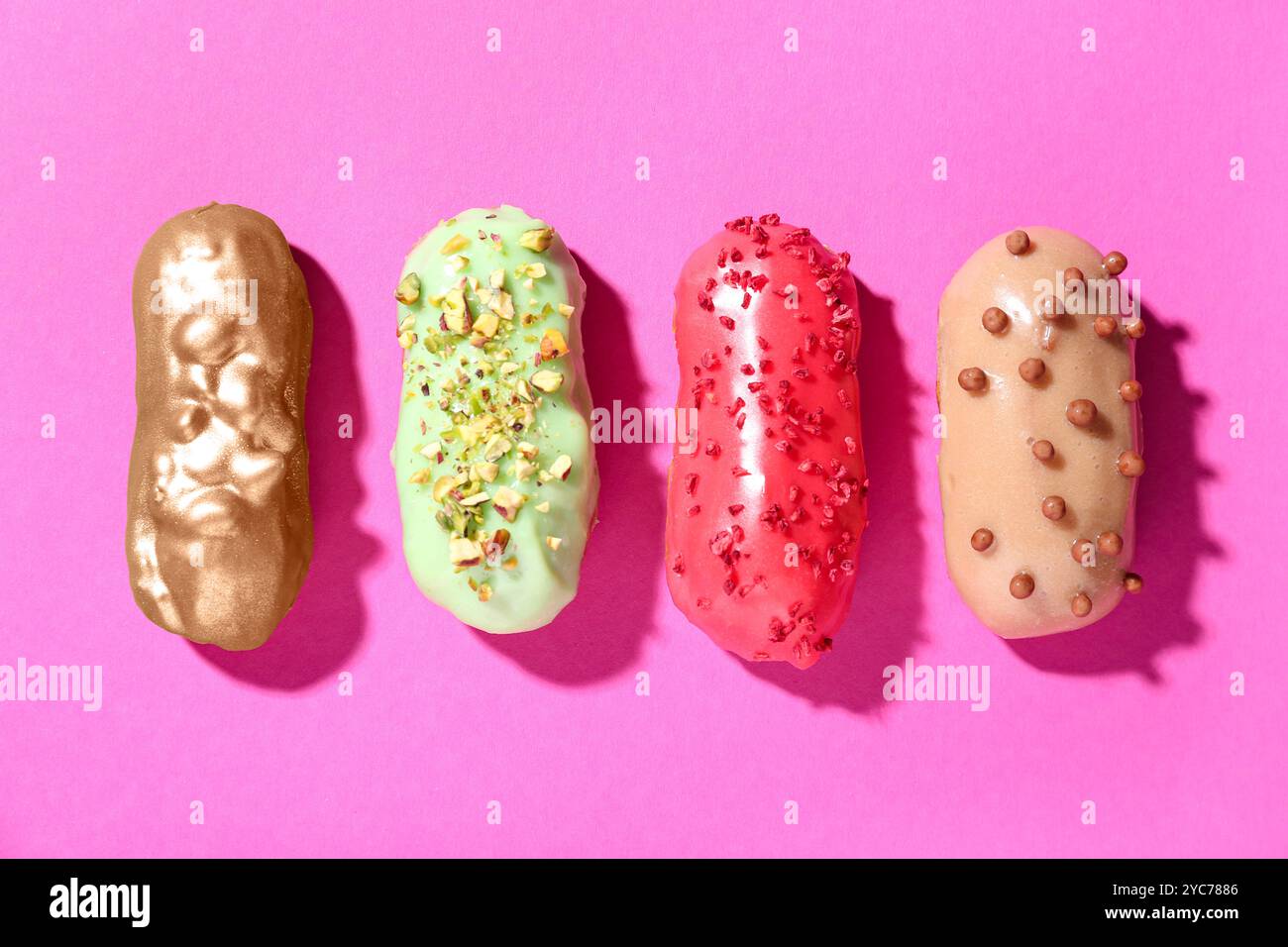 Delicious glazed eclairs on pink background Stock Photo