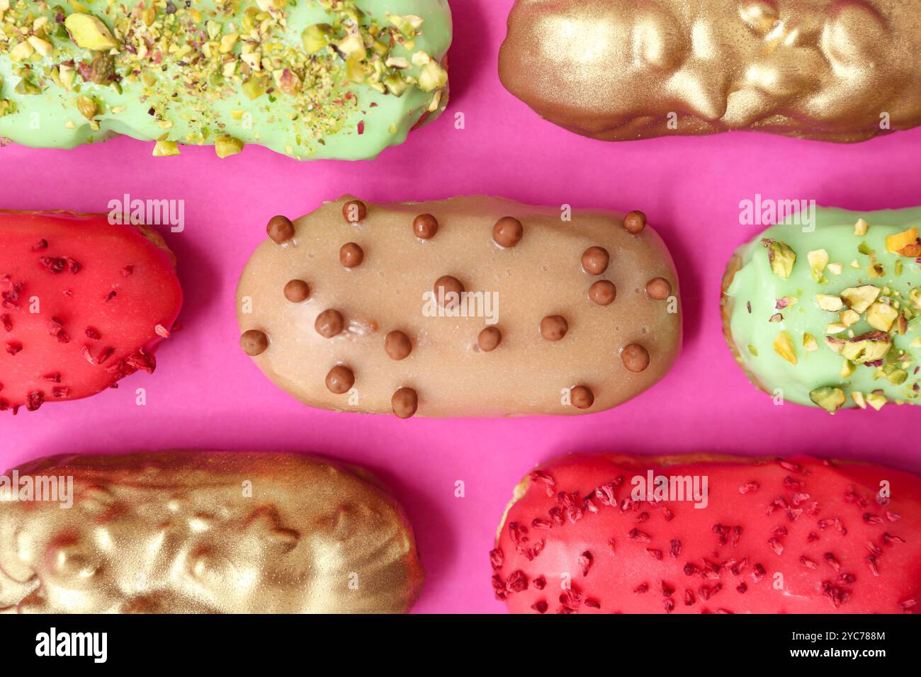 Composition with tasty glazed eclairs on pink background Stock Photo