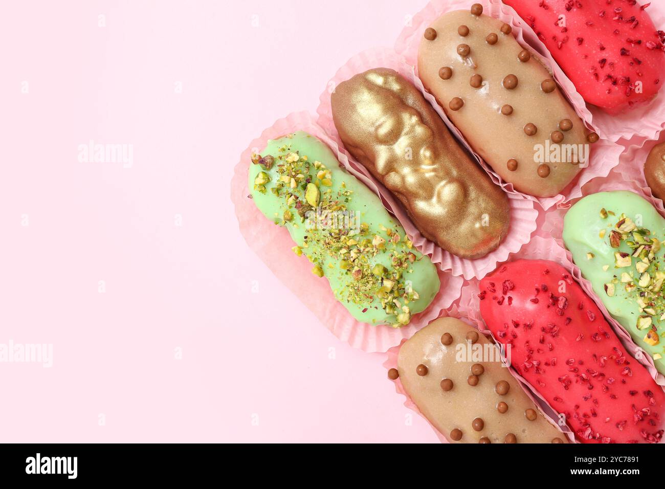 Composition with different glazed eclairs on pink background Stock Photo