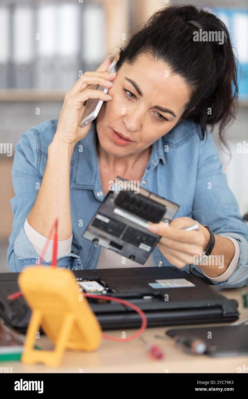engineer repairs laptop in her workshop Stock Photo