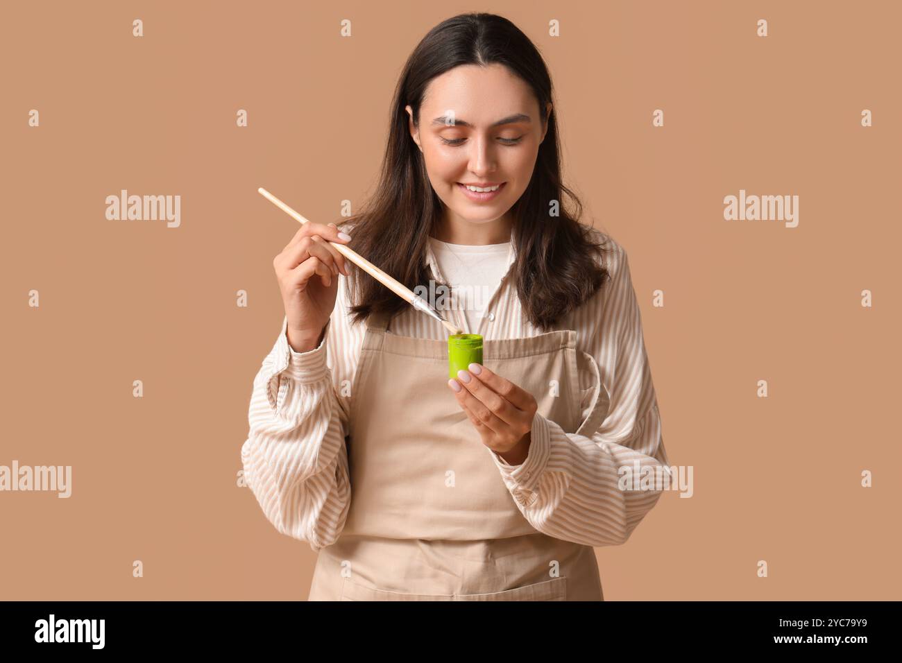 Beautiful female artist with brush and paint on beige background Stock ...