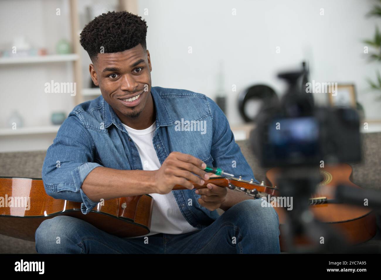 african american man tuning acoustic guitar at home Stock Photo - Alamy