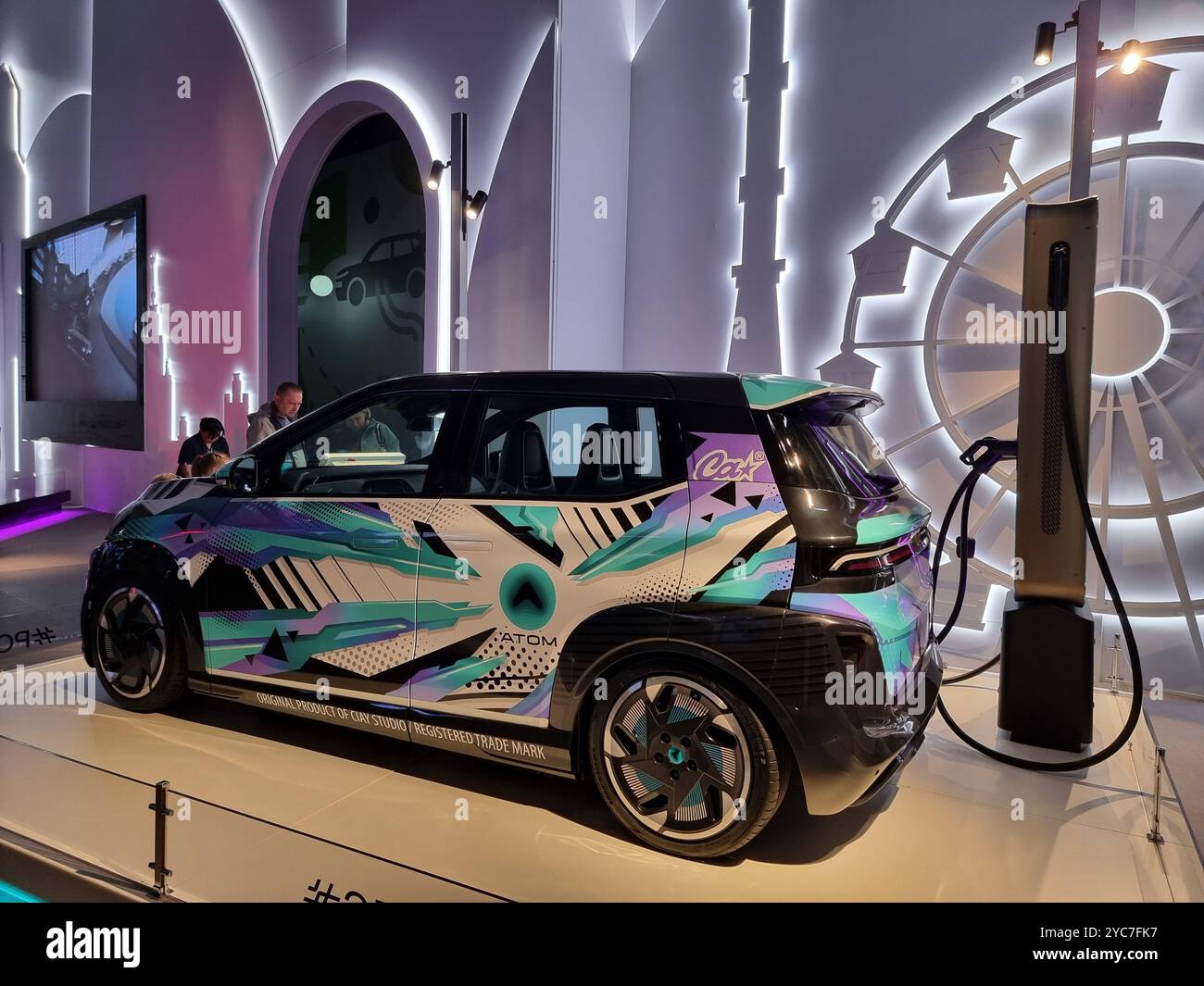 Russian electric car Atom from Russian automaker KAMAZ; connected to charging pole / charging station - Smartphone Captured Stock Image