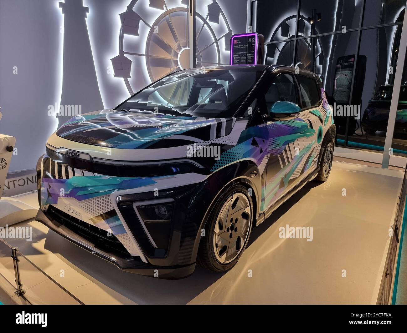 Russian electric car Atom from Russian automaker KAMAZ; connected to charging pole / charging station - Smartphone Captured Stock Image