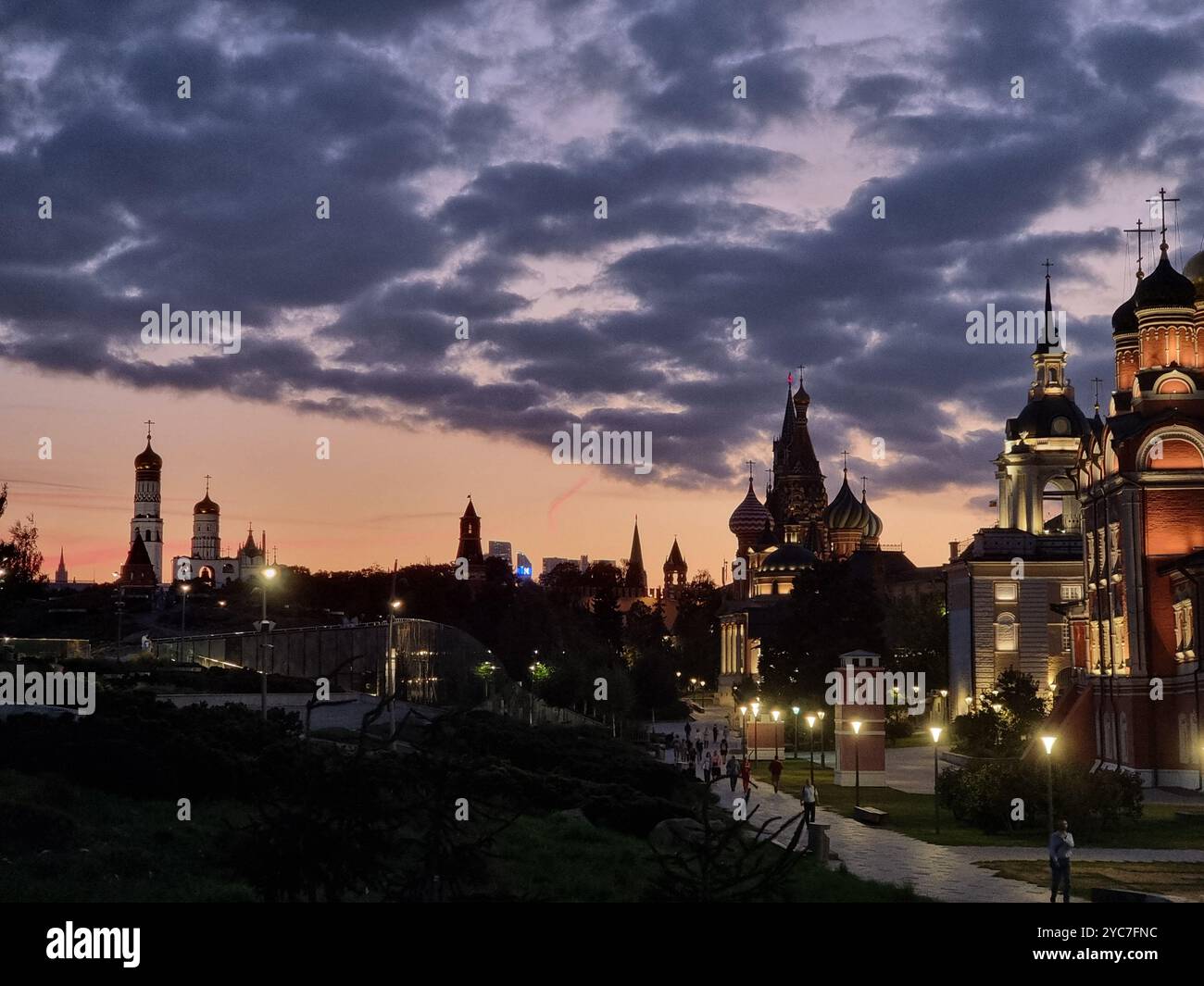 Nightly view from Zaryadye Park of skyline of Moscow with numerous lit cupolas, towers, churches; cloudy sky at blue hour - Smartphone Captured Stock Image
