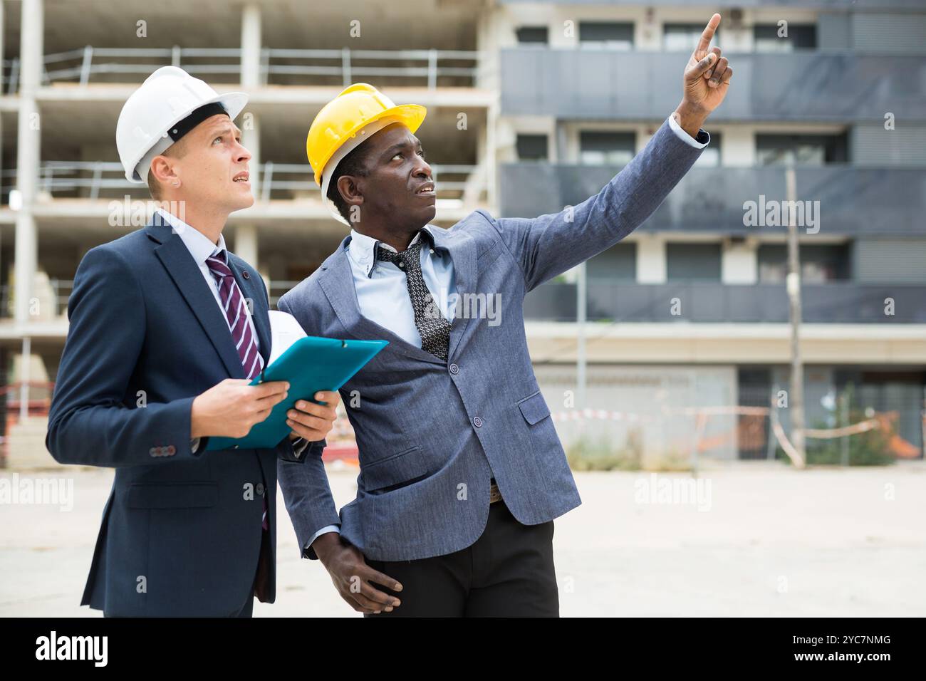 Two architects inspect the construction of new building. One of them ...