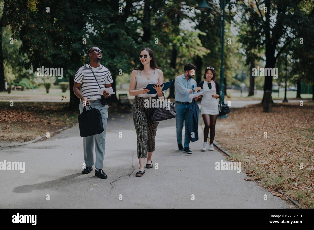 Business people walking and collaborating in a park setting Stock Photo ...