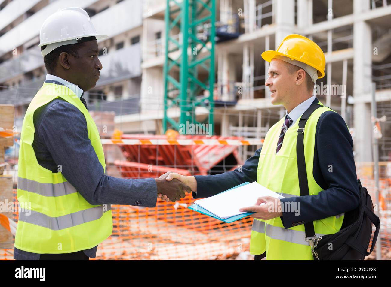 Two engineers concluding agreement and shaking hands Stock Photo