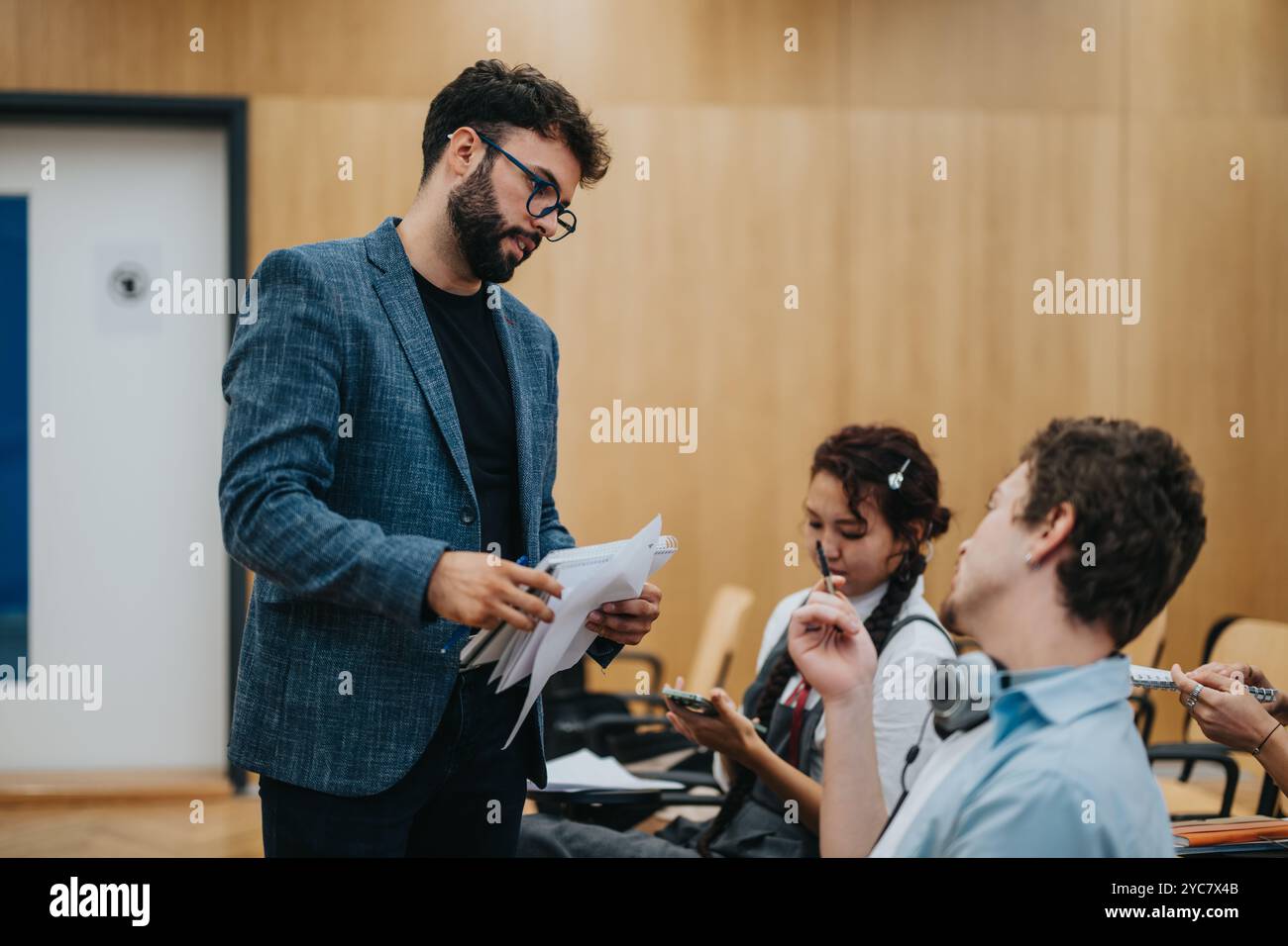 Engaged students consulting professor during an interactive class discussion Stock Photo