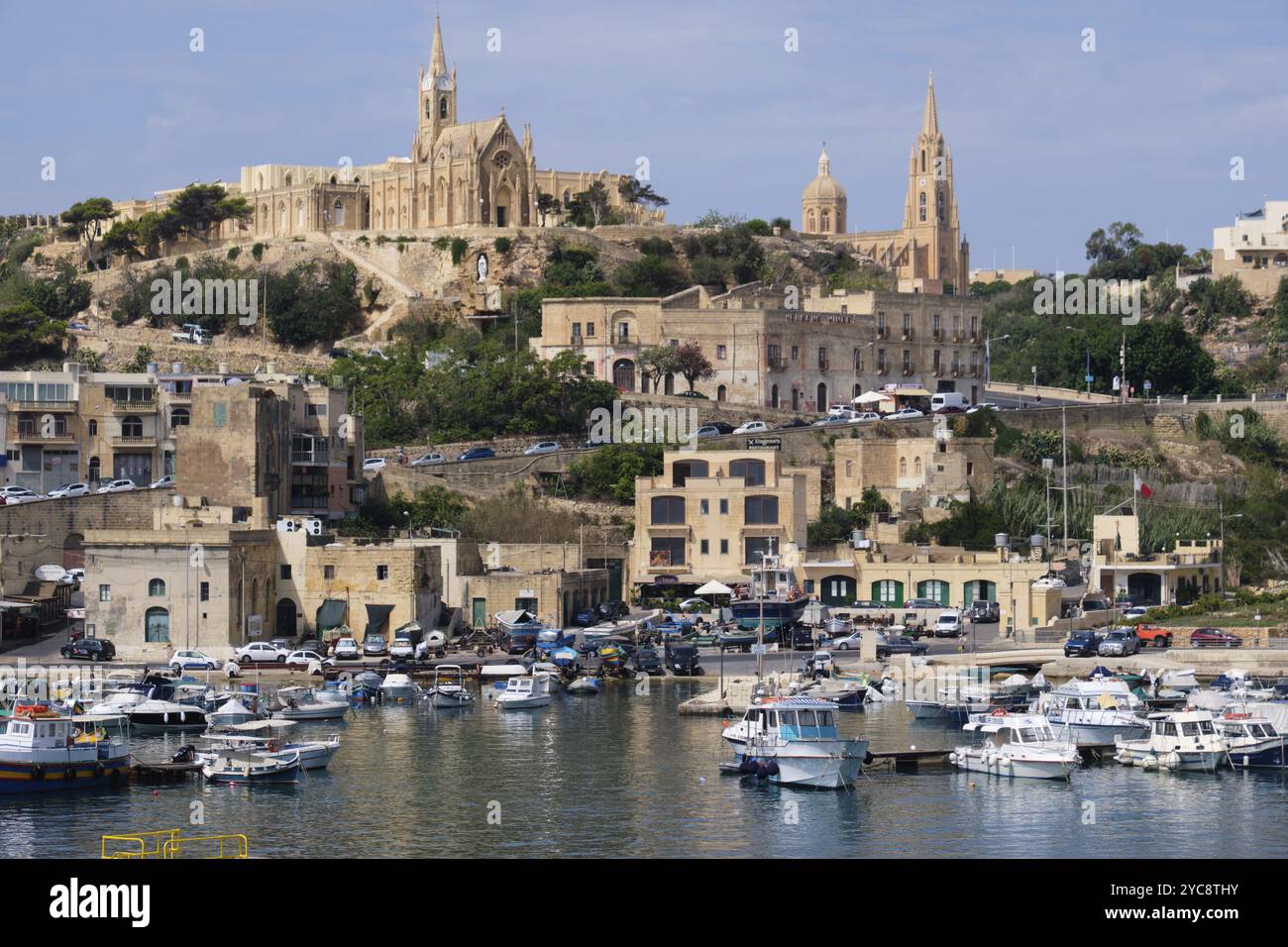 This bustling harbour full of fishing boats is the first place which greets visitors to Gozo, Mgarr, Malta, Europe Stock Photo