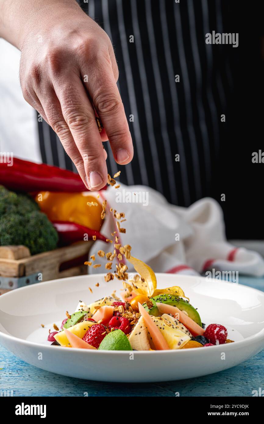 Mixed fruit salad with fruits such as banana, strawberry and pineapple on a white porcelain plate Stock Photo