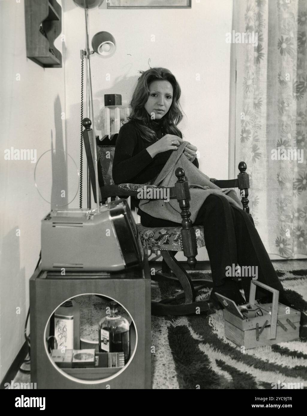 Woman sitting in a rocking chair knitting at home, Italy 1970s Stock ...