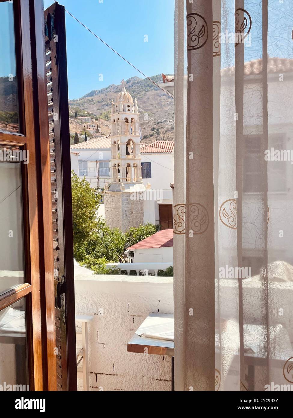 Church and mountains view from balcony on Hydra, Greece. - Smartphone Captured Stock Image