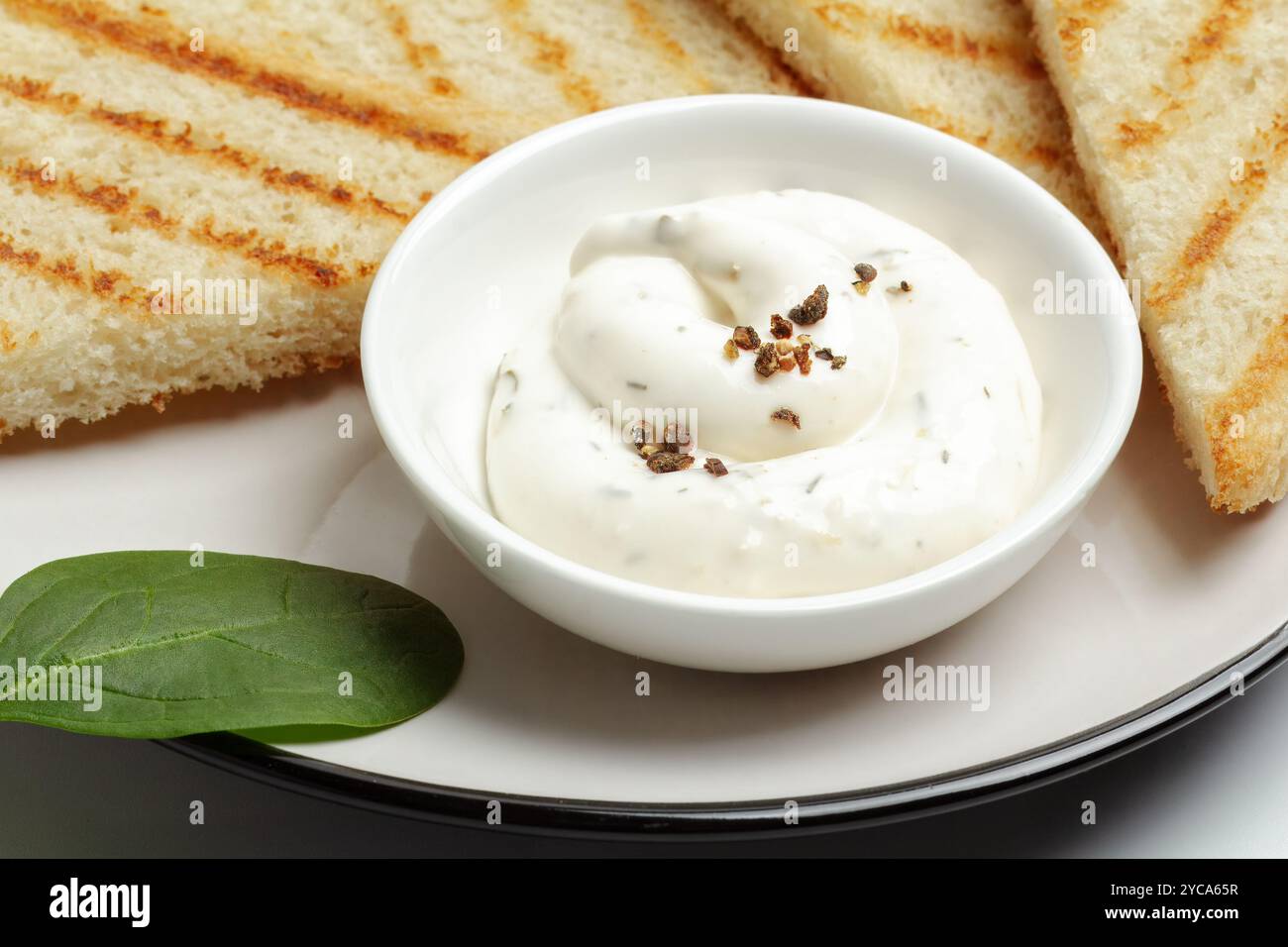 Cup with cheese sauce on the kitchen table. Stock Photo