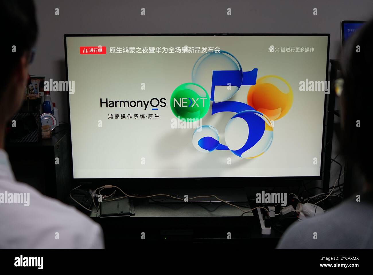A woman and her children watch the "Huawei Harmony OS operating system ...