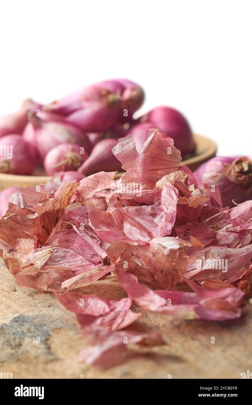 pile of onion peel with shallots or small red onions on table top, useful and beneficial discarded vegetable skin or food waste Stock Photo