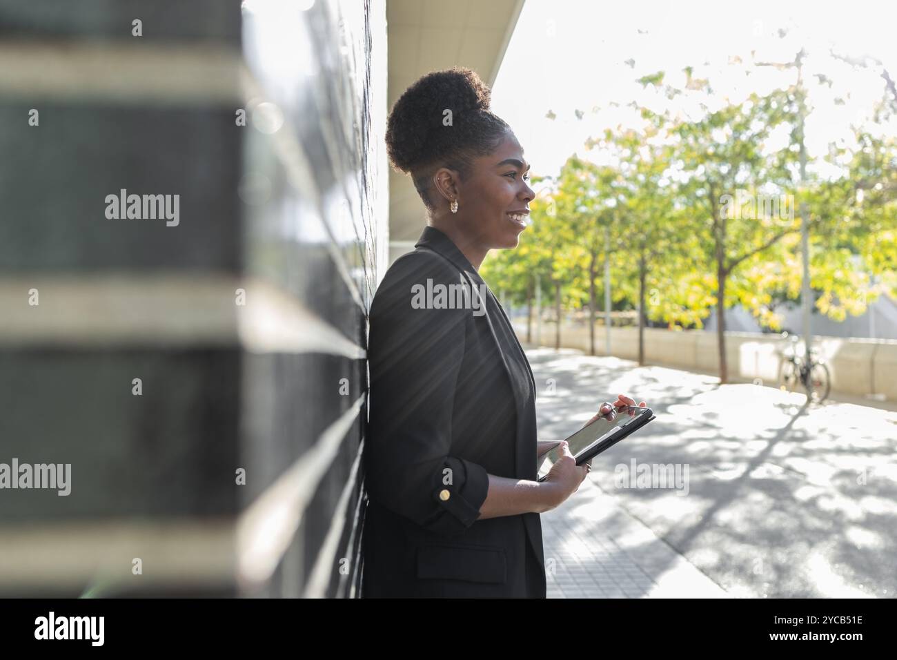 Side view of smiling African American businesswoman holding a tablet ...