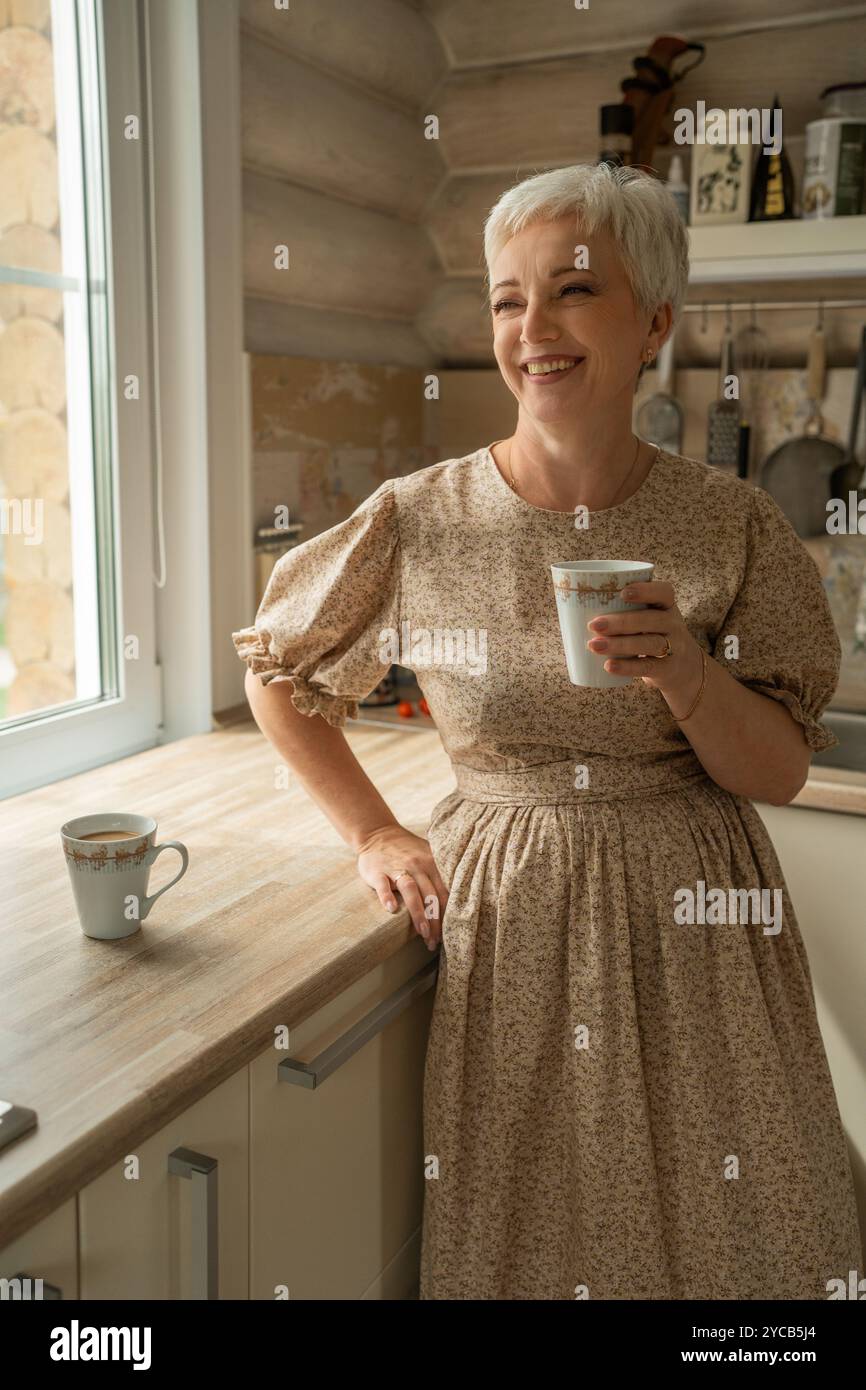 A cheerful mature woman with short gray hair, standing in a rustic ...
