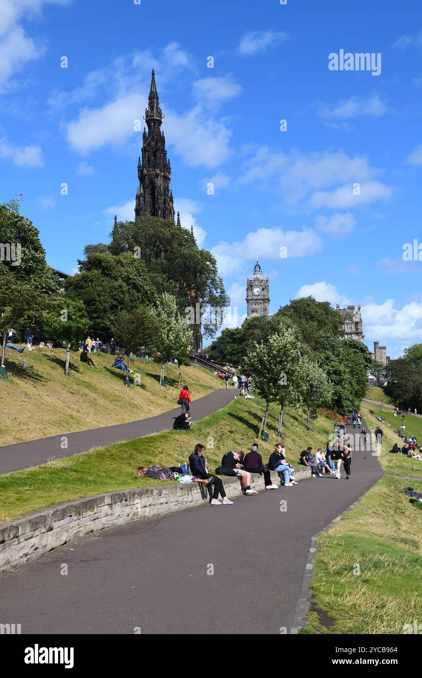 visitors relax in the sunshine in East Princes Street Gardens in Edinburgh, Scotland. Stock Photo