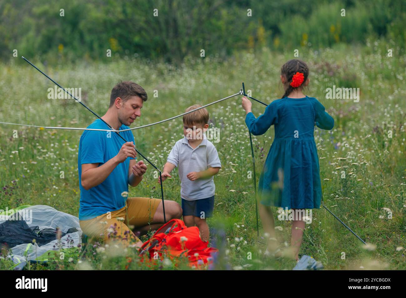Embarking on a Family Camping Adventure Enjoying the Excitement of Setting Up a Tent in Beautiful Nature Stock Photo