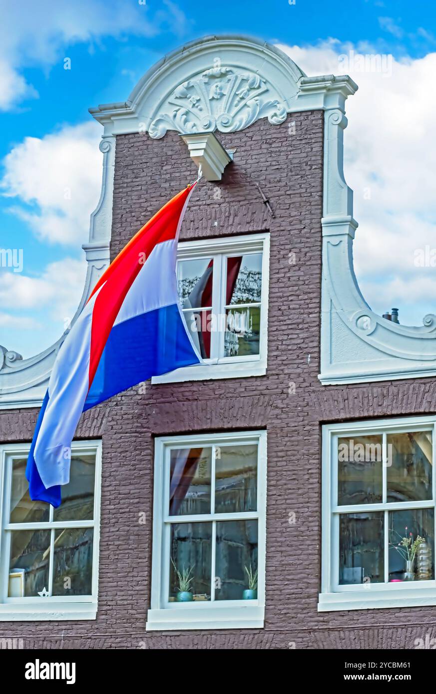 Dutch flag against a medieval facade from a house in Amsterdam the ...