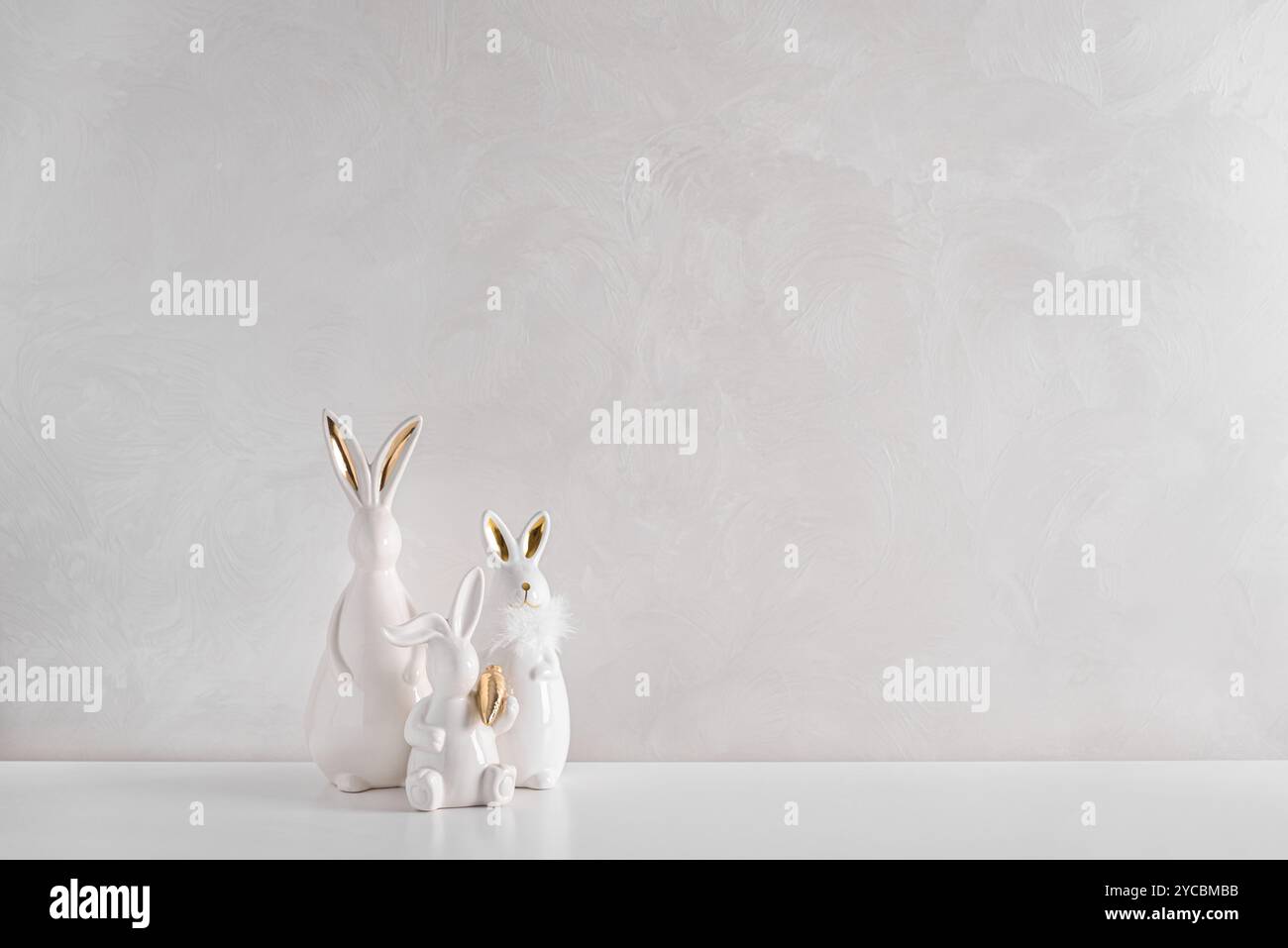 Three Easter rabbits figurines on white background. Easter celebration concept. Copy space. Front view Stock Photo
