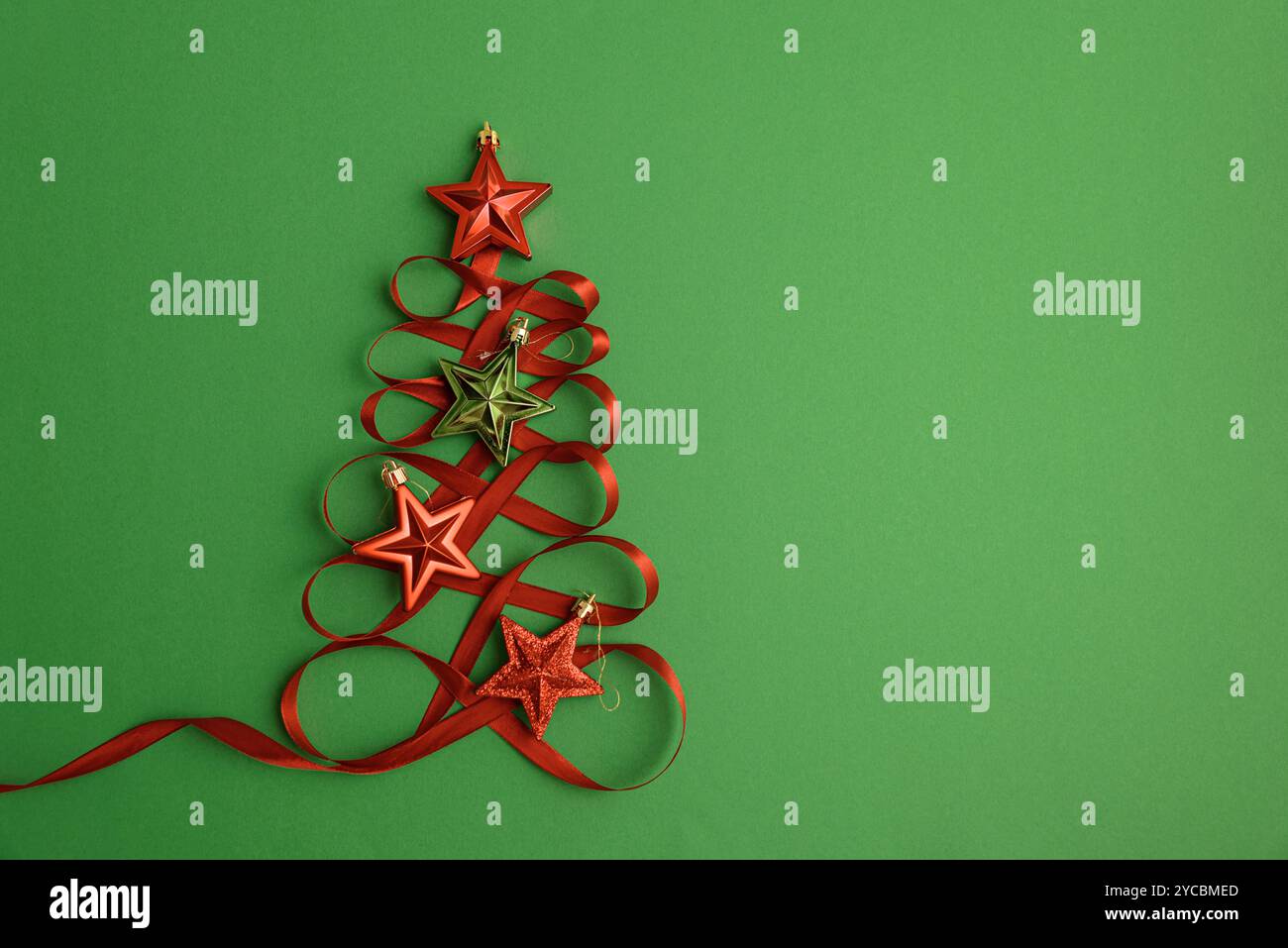 Christmas tree made of red ribbon and star shape toy on green ...