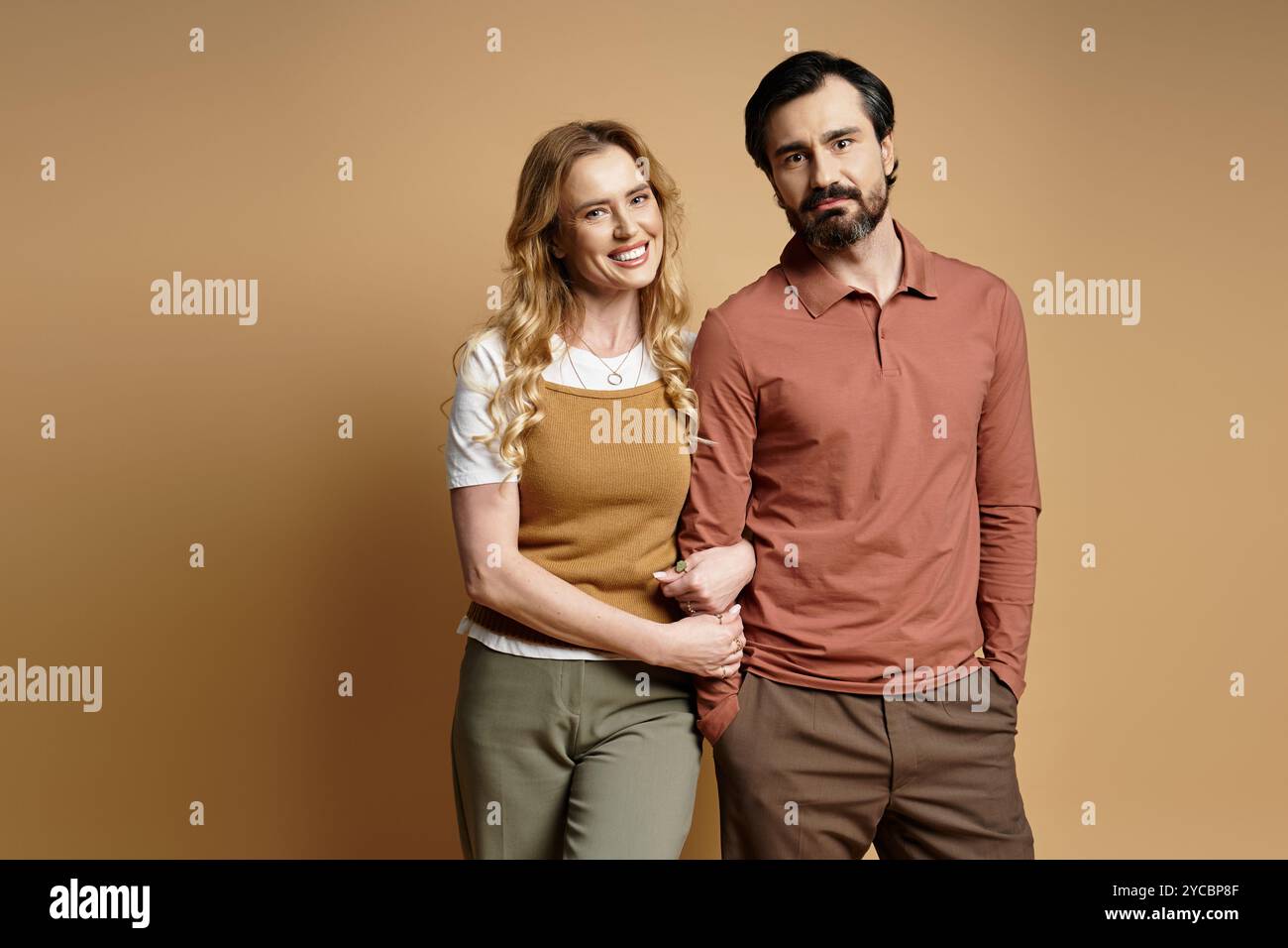 Stand Close A middle aged couple stands close together, smiling happily in a ...