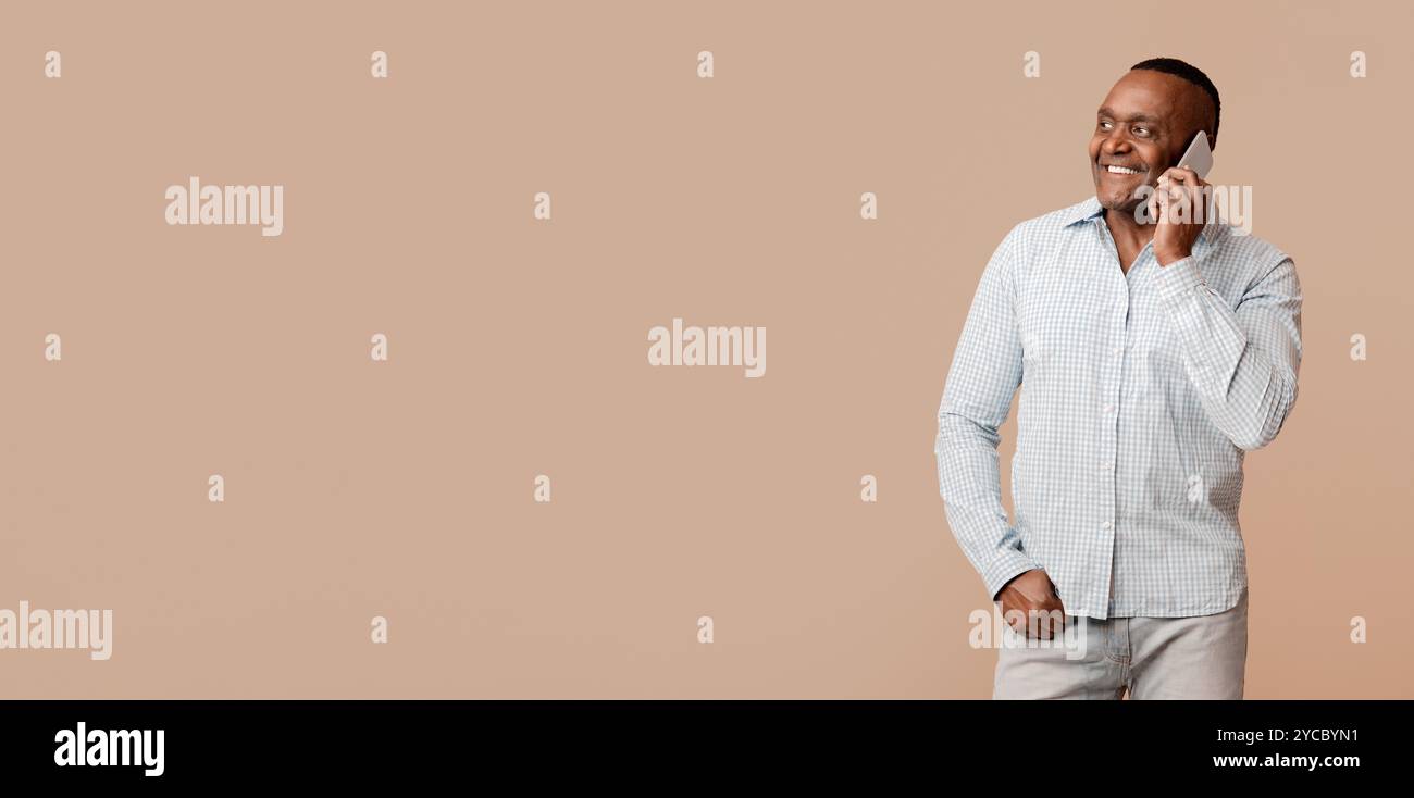 Positive mature afro man talking on cellphone Stock Photo