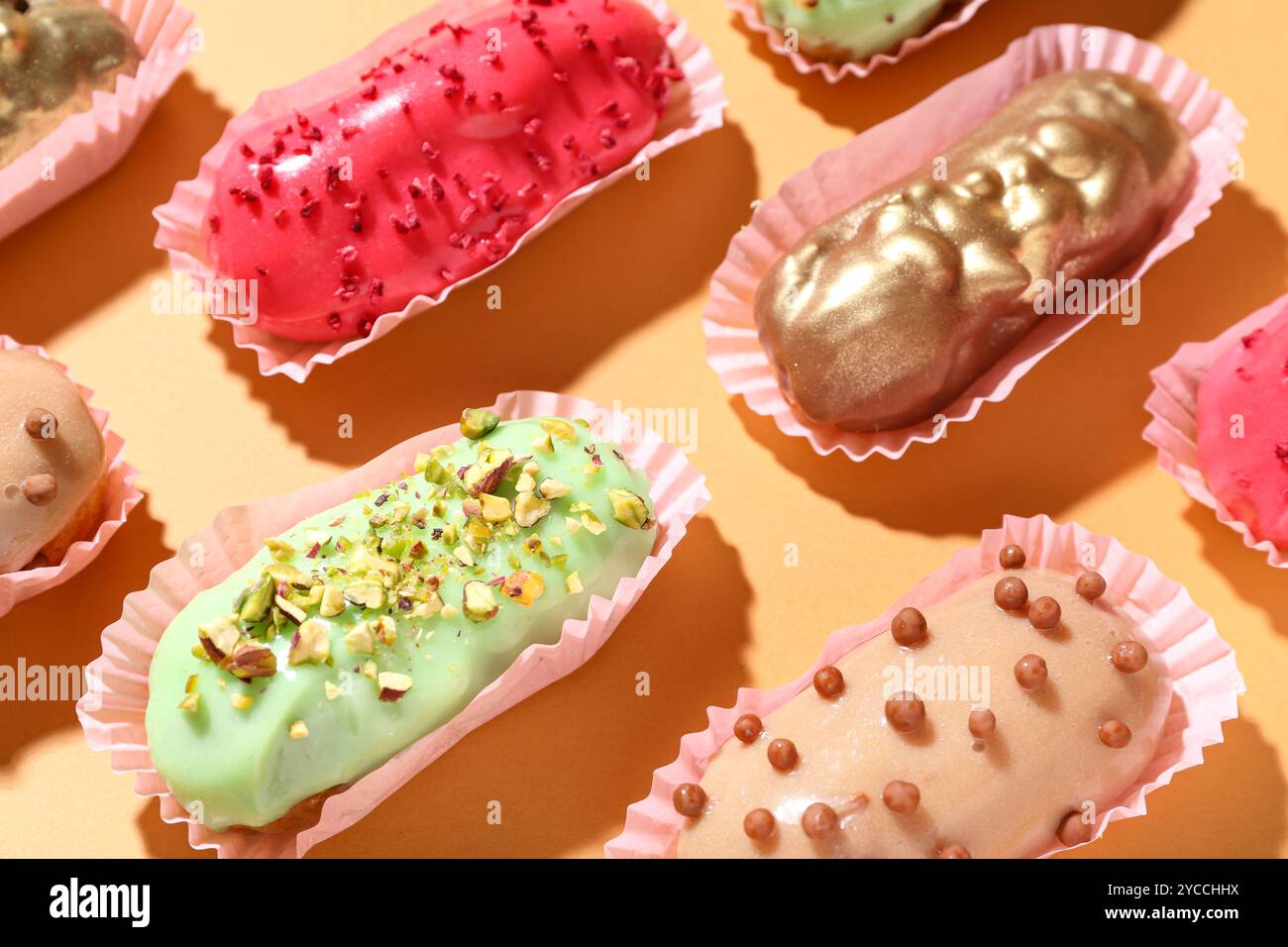 Composition with different glazed eclairs on color background Stock Photo