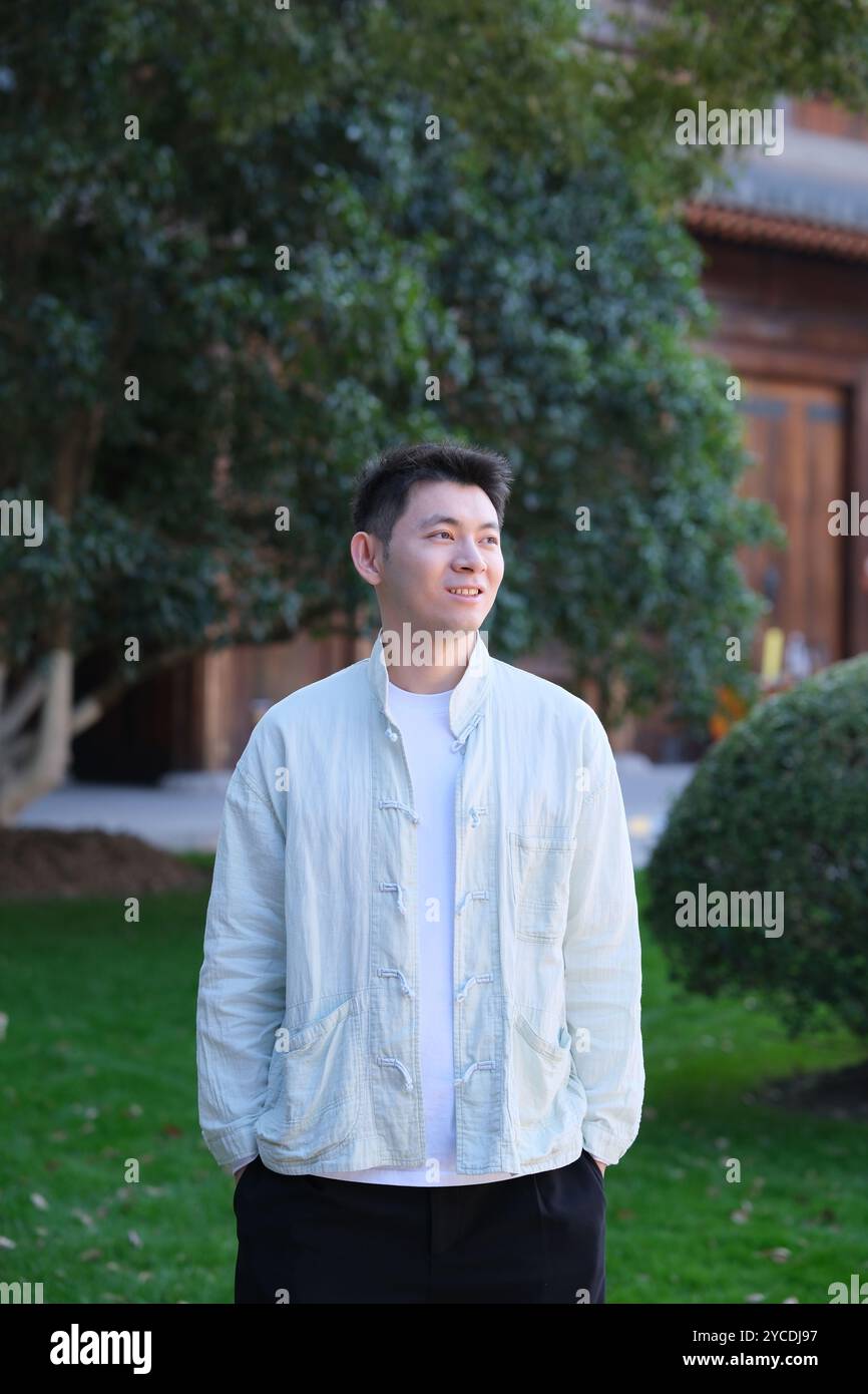 smiling Chinese young man looking away Stock Photo
