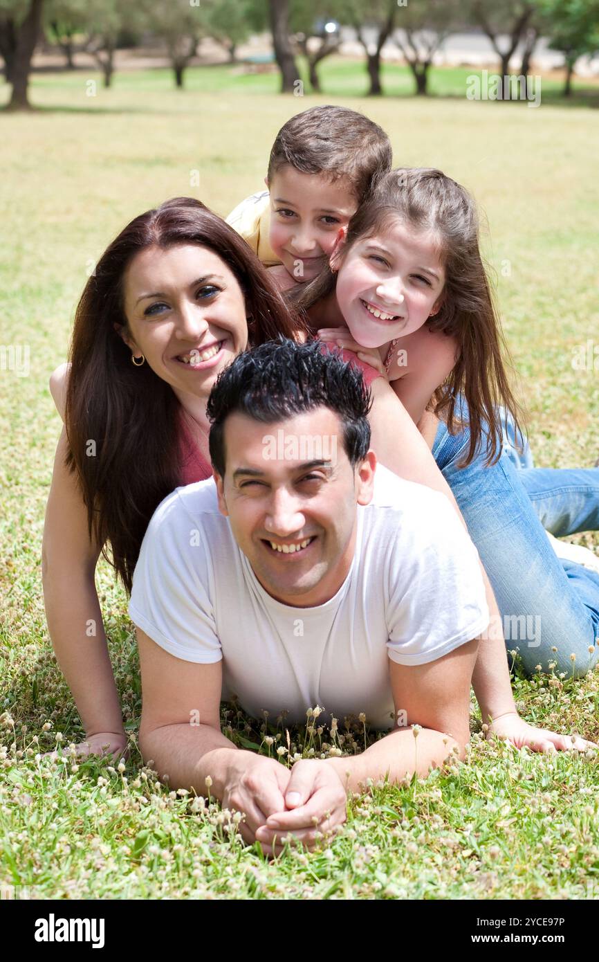 Happy family lying in the grass field Stock Photo - Alamy