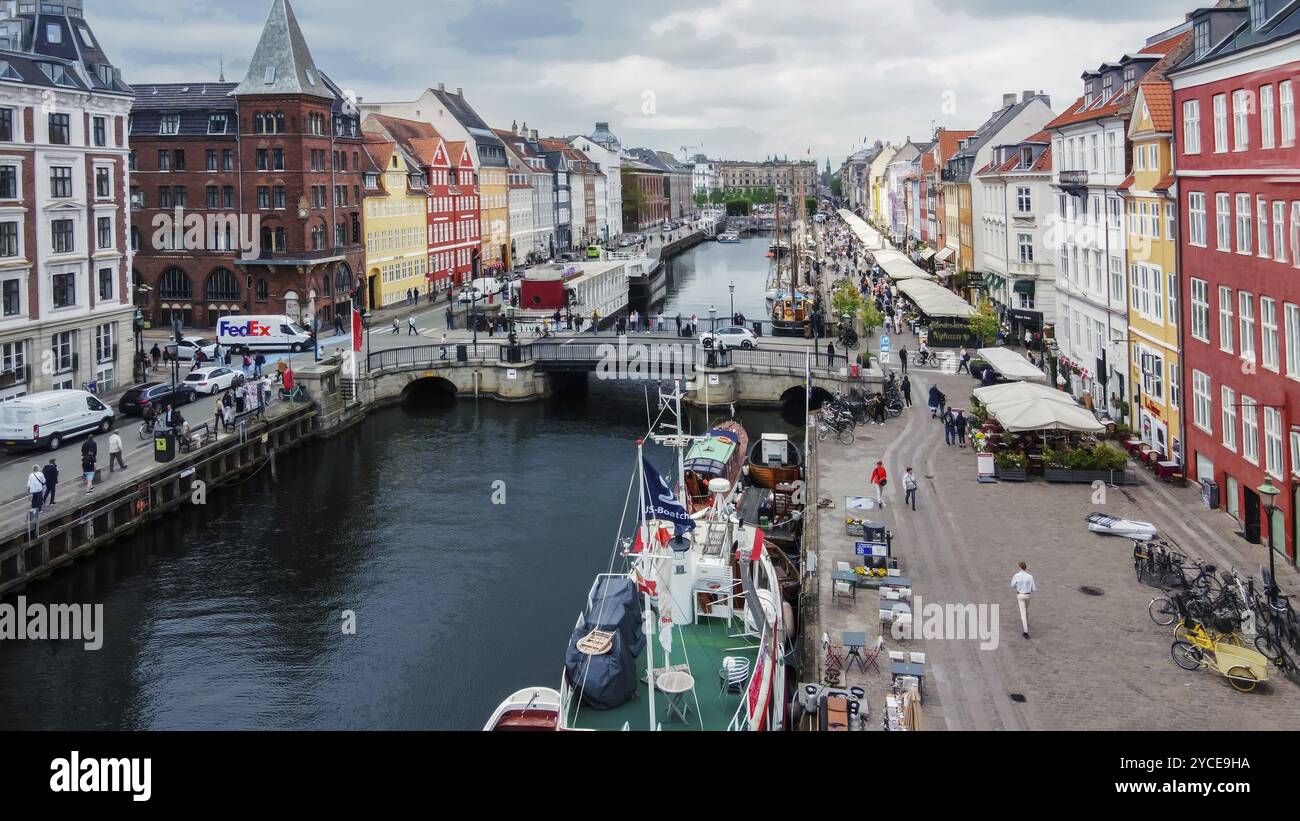 04-24-2023 Copenhagen DEN One if landmark in Copenhagen, Nyhaven (old por) with cafe and old (historic) ships, sailboats, Tourboats start her around C Stock Photo