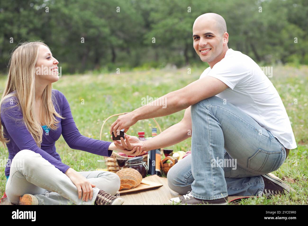 Couple sitting in blanket smiling with picnic mode Stock Photo