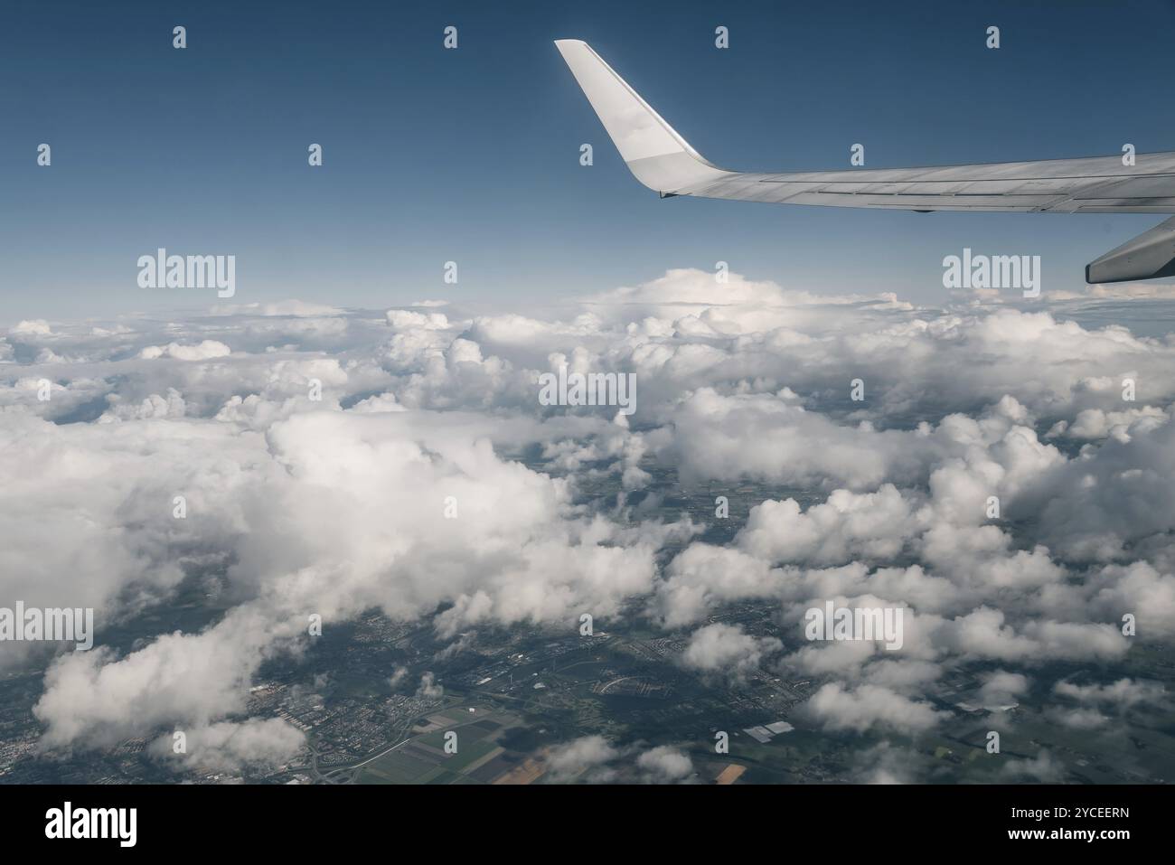 Wing of an airplane flying above the clouds Stock Photo - Alamy