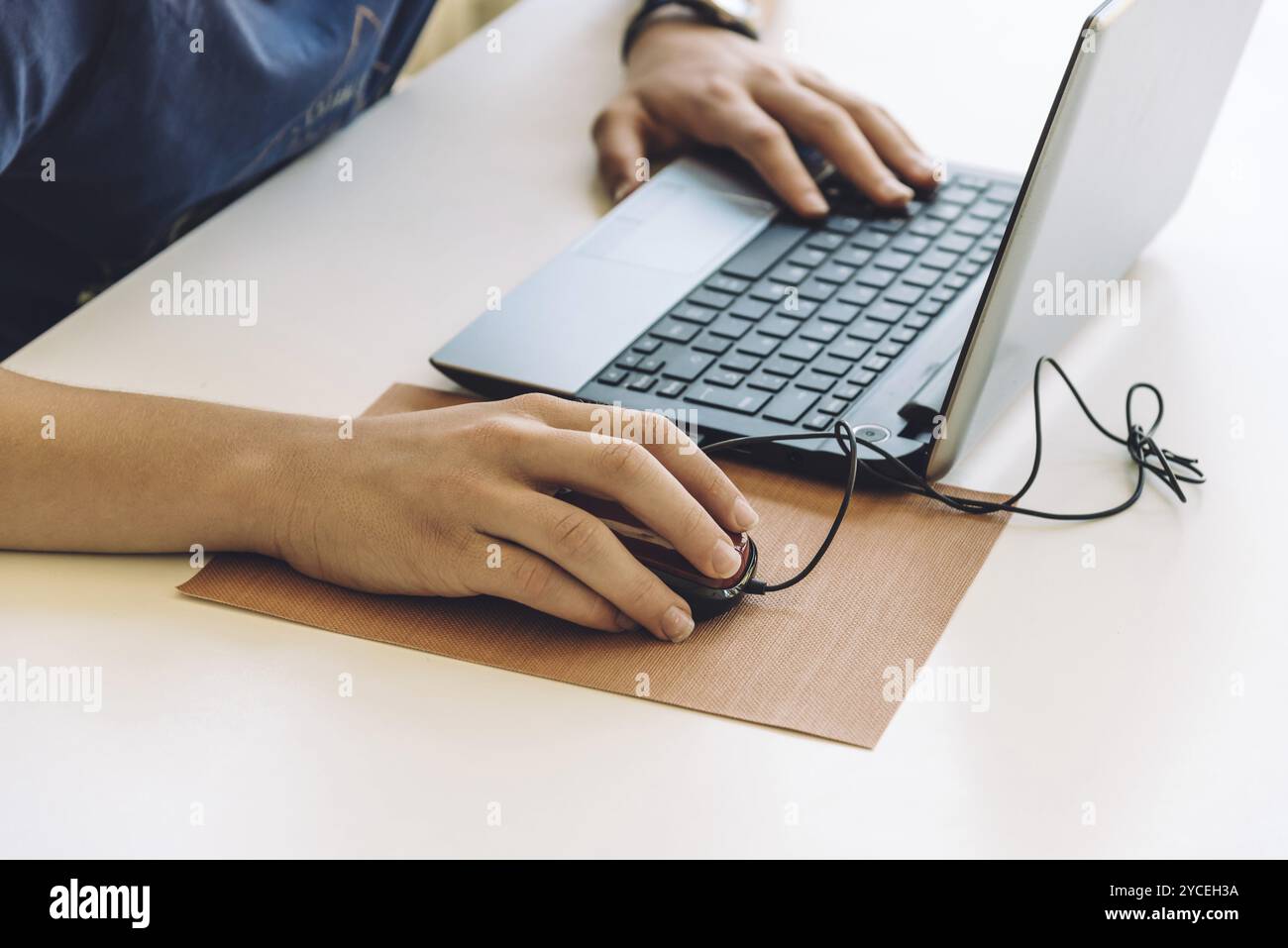 Young man working with laptop, hands on notebook computer and mouse ...