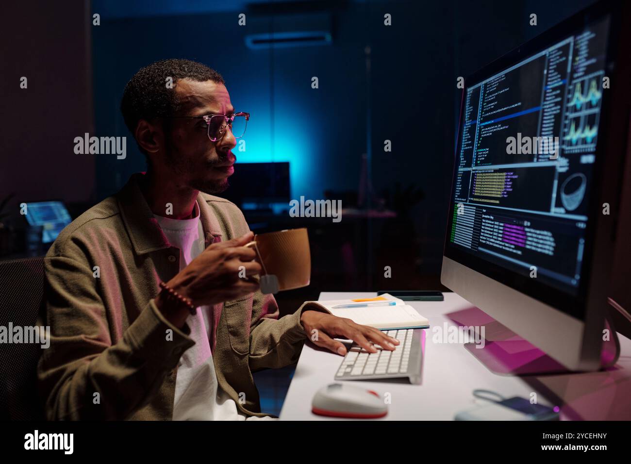 Coding at Night in Modern Office Environment Stock Photo