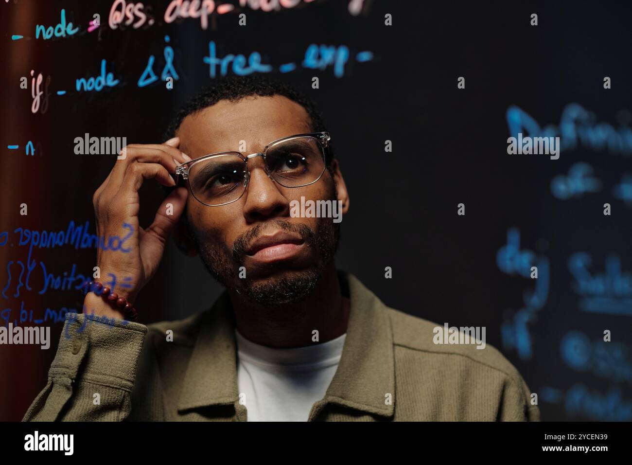 Thoughtful Man Analyzing Data on Transparent Board Stock Photo