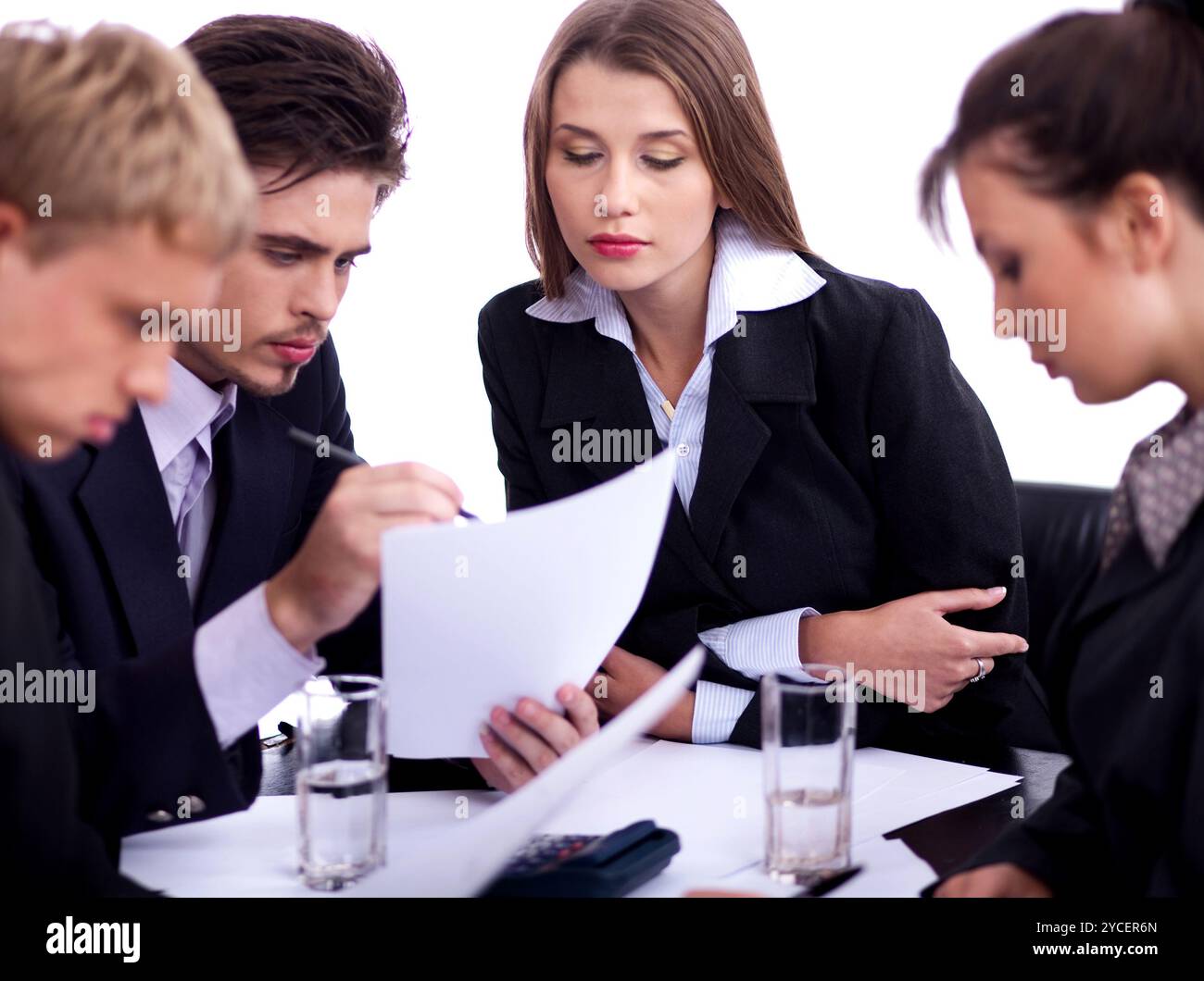 Young professionals business people discussing seriously in their meeting with documents over white background Stock Photo