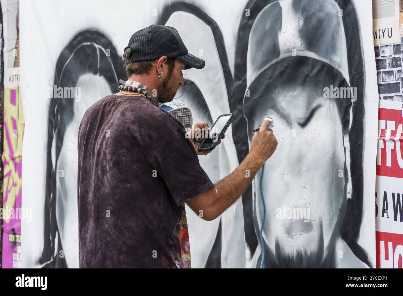 London, UK, August 25, 2023: Artist painting graffiti on the wall in Brick Lane in Shoreditch in the East End Stock Photo