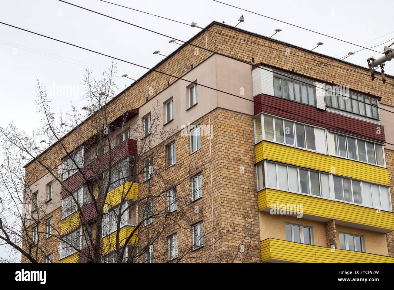 A solid brick building featuring a balcony located at the top of the ...