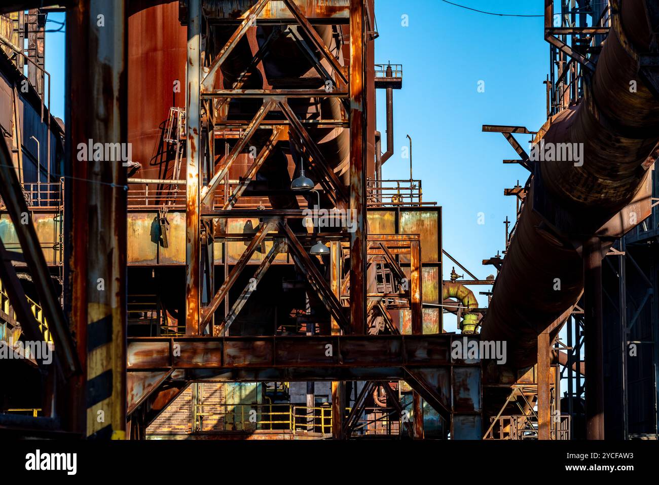 Rusty Factory Components Rusty industrial structure with pipes and metal beams in an abandoned ...