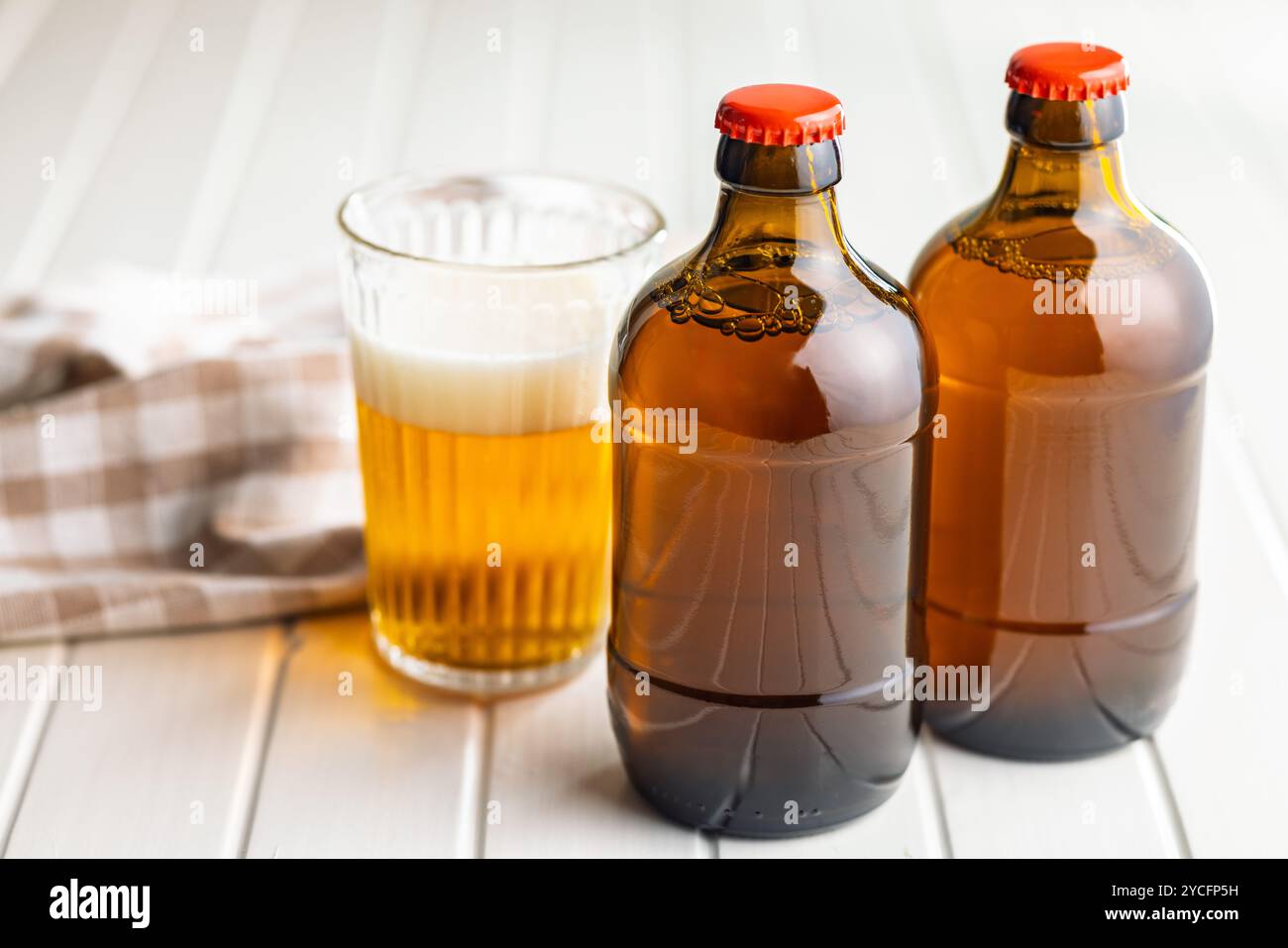 Two beer bottles on a white table. Stock Photo