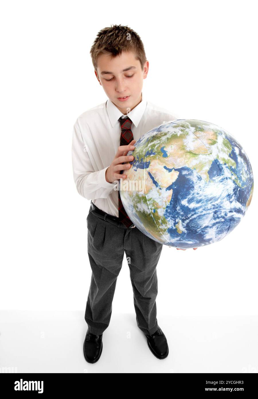 A student schoolboy holds a blow up ball of the Earth.   Pictures of the Earth from Nasa.  Eg, geography, astronomy, travel, environment, geo politics Stock Photo