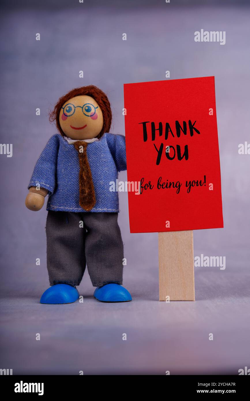 Toy Message A wooden toy figure holds a red sign with an uplifting message ...