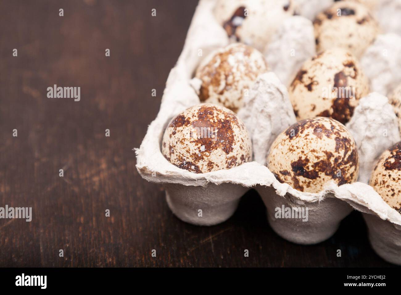 Many fresh speckled quail eggs in cardboard container Stock Photo