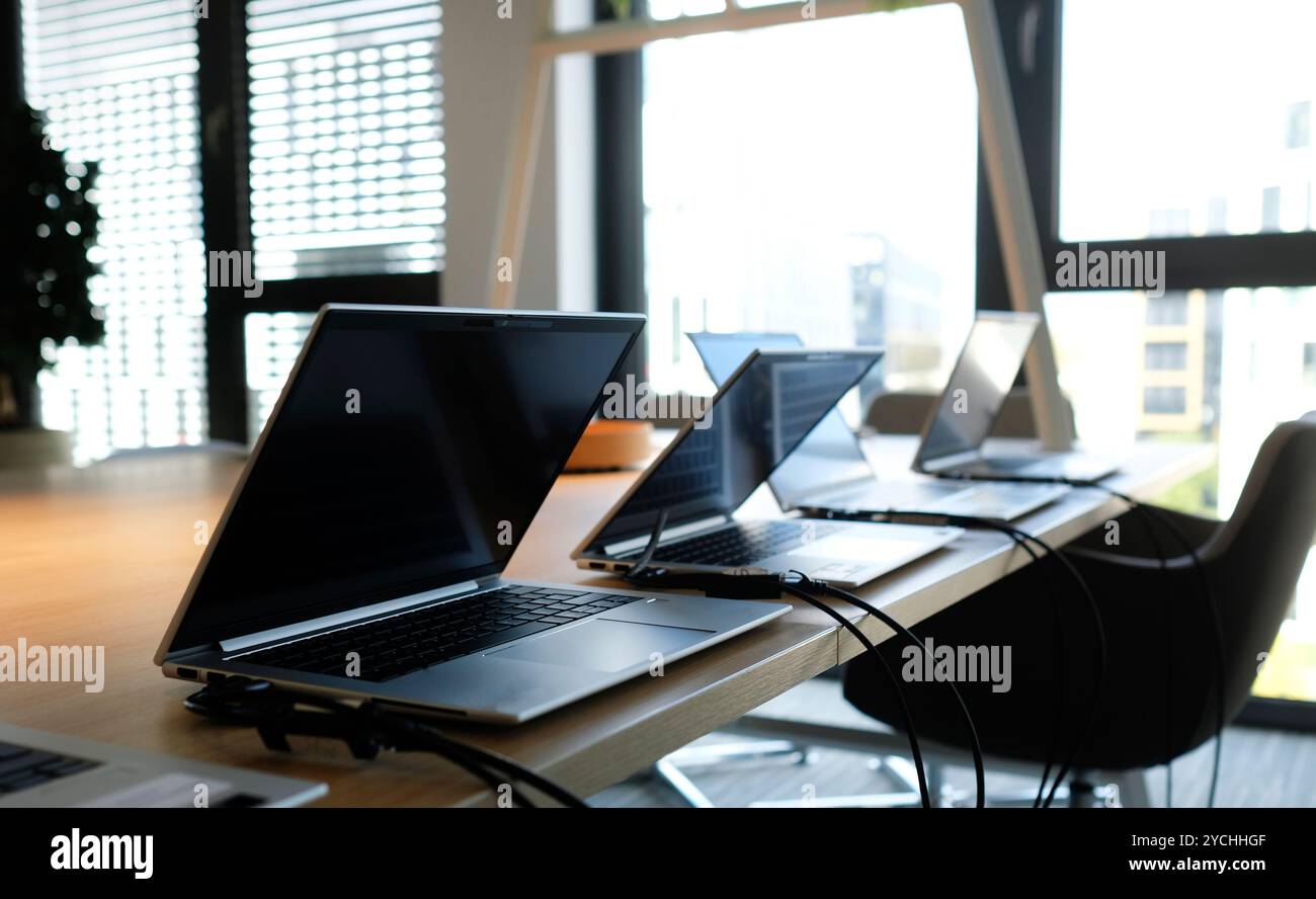 Laptops on a table in an empty co-working space Stock Photo